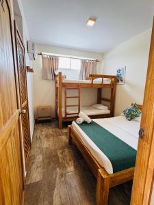 a bedroom with a bed and a bunk bed at Merakai Hostel Rincon del Mar in Rincón