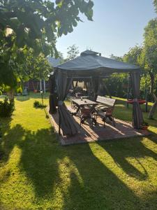 a picnic table and a tent in a park at Juka in Palanga