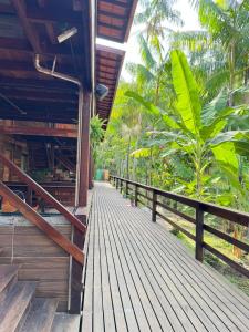 a wooden walkway outside of a house with trees at Hotel e Restaurante Tribo Combú in Belém