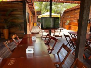 a dining room with tables and a television on a patio at Hotel e Restaurante Tribo Combú in Belém