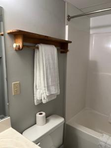 a bathroom with a toilet and towels and a shower at Valley Suites Extended Stay Hotel in Harrisonburg +13 photos