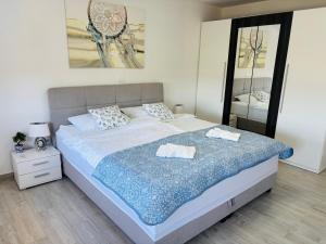 a bedroom with a large bed with two towels on it at Apartment Aurora in Ankaran