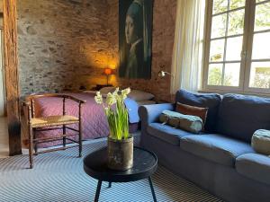 a living room with a blue couch and a table at Domaine Voilà in Génis +53 photos