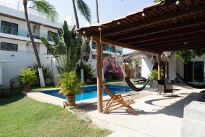 a hammock under a pergola next to a pool at Suku'un in Brisas de Zicatela