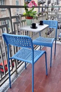 two blue chairs and a table on a balcony at Arcobaleno in Turin