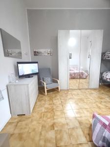 a living room with a tv and a chair and a table at A casa di Irene in Le Marmore