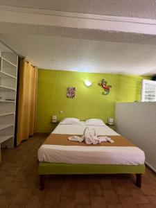 a bedroom with a bed with a towel on it at Les 2 Cocotiers - Studios in Sainte-Luce