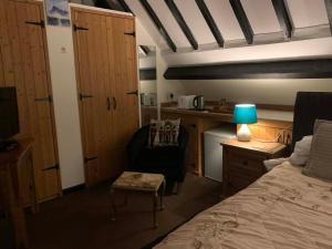 a bedroom with a bed and a chair and a table at Broadwalk 6 in Coltishall