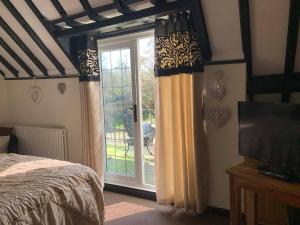 a bedroom with a bed and a window with curtains at Broadwalk 6 in Coltishall