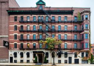 a large red brick building with a tree in front of it at Hotel Ivy Boston Common in Boston