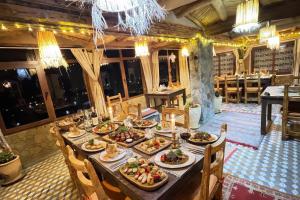 a long table with plates of food on it at Hotel Soleil Blue in Boumalne Dades +33 photos