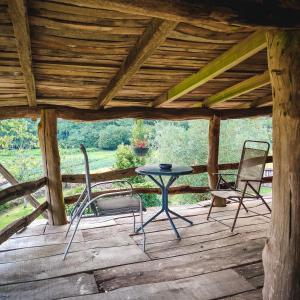 two chairs and a table on a wooden deck at Casa Perfeuto Maria in Cabana Moura 