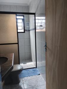 a bathroom with a shower with a toilet and a glass door at Casa de praia in Bertioga +41 photos