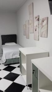 a bedroom with a bed and a black and white checkered floor at Pousada da Isa in Quatro Barras