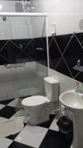 a black and white bathroom with a toilet and sink at Pousada da Isa in Quatro Barras