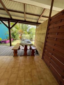 a patio with a picnic table on a deck at Les 2 Cocotiers - Studios in Sainte-Luce