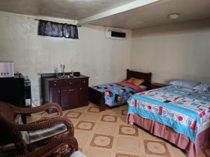 a bedroom with two beds and a sink and a chair at Sweet Dreams in Bluefields