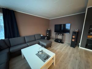a living room with a couch and a table and a tv at Northbound Sea View Retreat in Sortland