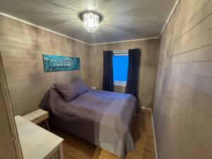 a small bedroom with a bed and a window at Northbound Sea View Retreat in Sortland