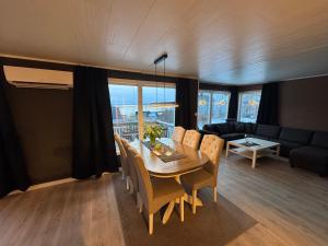 a dining room with a table and chairs and a couch at Northbound Sea View Retreat in Sortland