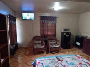a bedroom with two chairs and a tv on the wall at Sweet Dreams in Bluefields