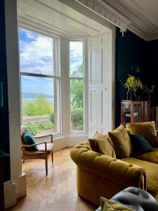 a living room with a couch and a large window at Wigtown House in Wigtown