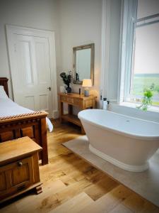 a bathroom with a large white tub and a window at Wigtown House in Wigtown +30 photos