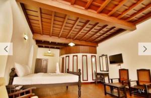 a bedroom with a bed and a tv in a room at The Heritage Kochi in Cochin