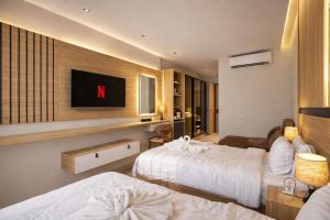 a hotel room with two beds and a tv on the wall at TAJ Suites Pyramids View Hotel in Cairo
