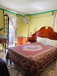 a bedroom with a large bed and a window at Hotel Plaza Macondo in Comonfort