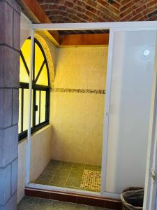 a shower with a glass door in a bathroom at Hotel Plaza Macondo in Comonfort