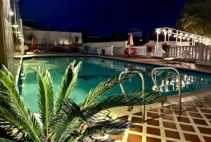 a swimming pool with a palm tree next to a building at Hotel Emperador in Barbosa +33 photos