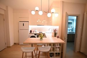 a kitchen with a table and chairs and a refrigerator at Lilaki in Larisa