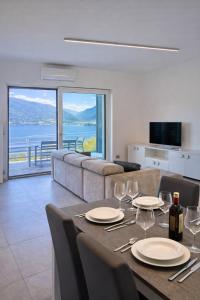 a dining room with a table with wine glasses at Bluelow Lakeview house in Dervio