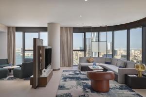 a living room with a couch and a tv at Conrad Bahrain Financial Harbour in Manama