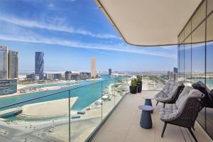 a balcony with two chairs and a view of the city at Conrad Bahrain Financial Harbour in Manama