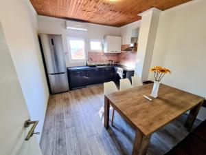a kitchen and dining room with a wooden table at House Beachfront Delight in Neviđane
