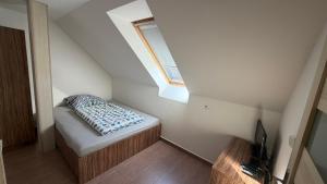 a small room with a bed and a window at Ubytování Divišov in Divišov +3 photos