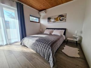 a bedroom with a bed and a large window at House Beachfront Delight in Neviđane