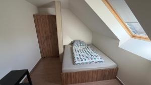 a small bed in a room with a window at Ubytování Divišov in Divišov
