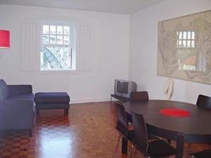 a living room with a table and chairs and a tv at Porto Riverside in Porto