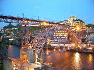 a bridge over a river with a train on it at Porto Riverside in Porto