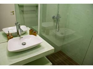 a white bathroom with a sink and a shower at Porto Riverside in Porto