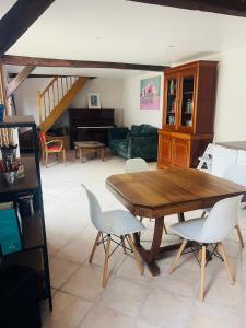 a living room with a wooden table and chairs at La maisonnette in Warmeriville +7 photos