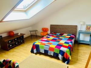 a bedroom with a colorful bed in a attic at La maisonnette in Warmeriville