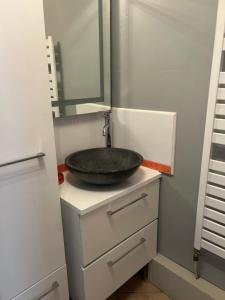 a bathroom with a sink on top of a dresser at La maisonnette in Warmeriville