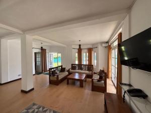 a living room with a couch and a tv at MGM Daisy Resorts in Nuwara Eliya