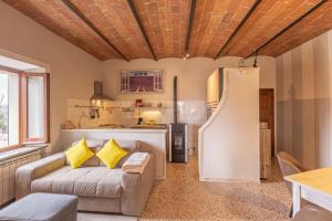 a living room with a couch and a kitchen at Dimora San Lazzaro Tuscany in Cetona