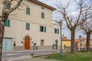 a large white building with green shutters at Dimora San Lazzaro Tuscany in Cetona