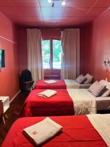 a bedroom with three beds with red sheets at Hotel Windsor Mendoza in Mendoza +59 photos
